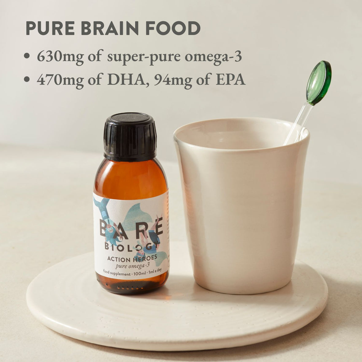 Bottle of Action Heroes Omega-3 fish oil for kids with the title 'Pure Brain Food' in writing on the top left hand corner. Supplement displayed next to a cup on a white ceramic surface