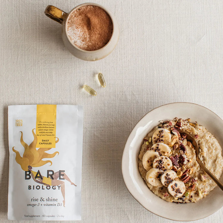 bare biology rise & shine omega 3 and vitamin d3 on a kitchen table with porridge and coffee