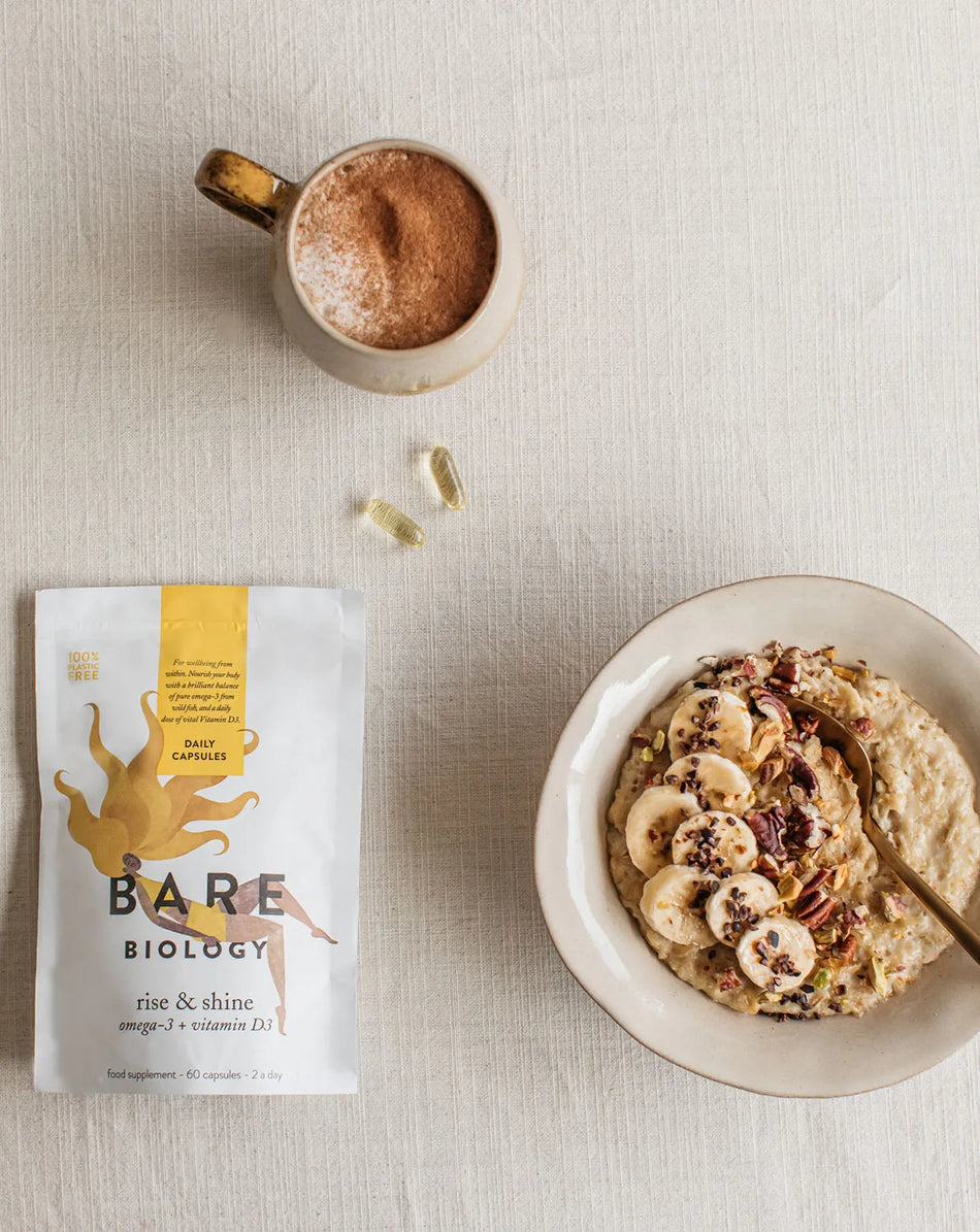 bare biology rise & shine omega 3 and vitamin d3 on a kitchen table with porridge and coffee