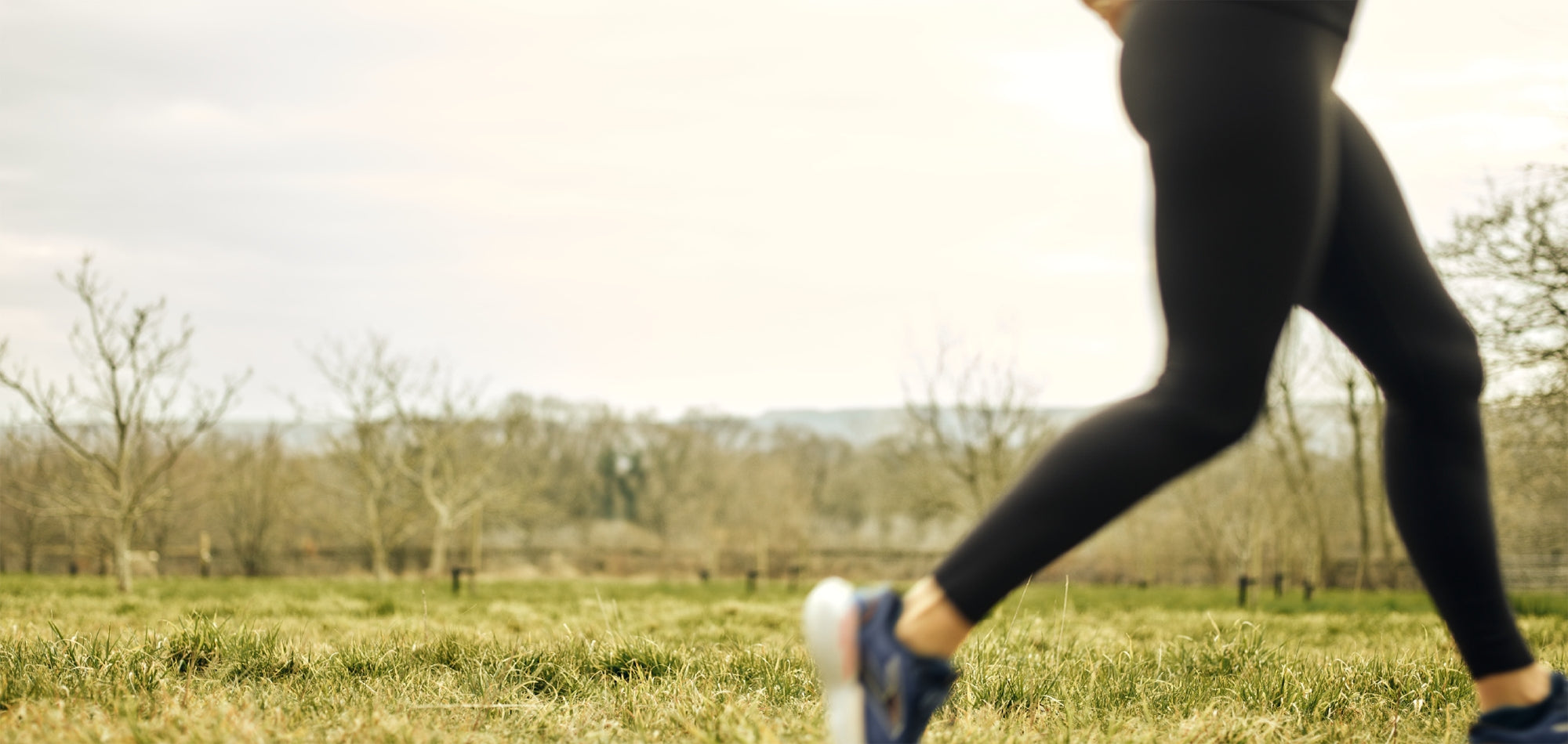 Person running in a field with trees in the background
