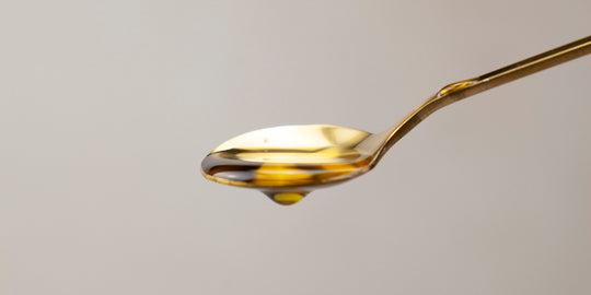 Bare Biology Life & Soul Omega-3 Liquid on a golden spoon