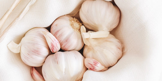 garlic bulbs in a basket with white cloth