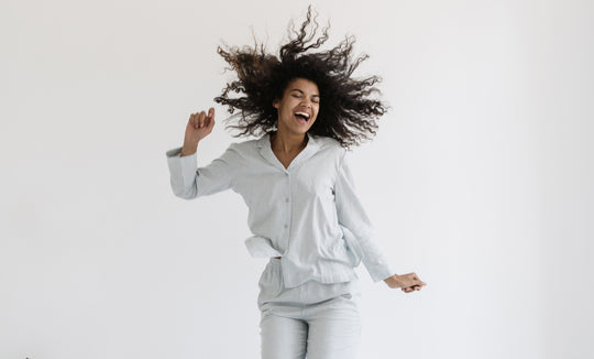 a woman jumping on her bed