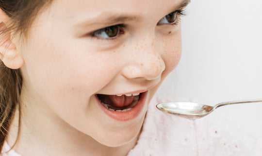 a child taking a spoon of fish oil