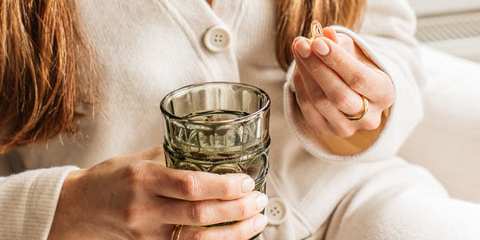 a woman holding a capsules