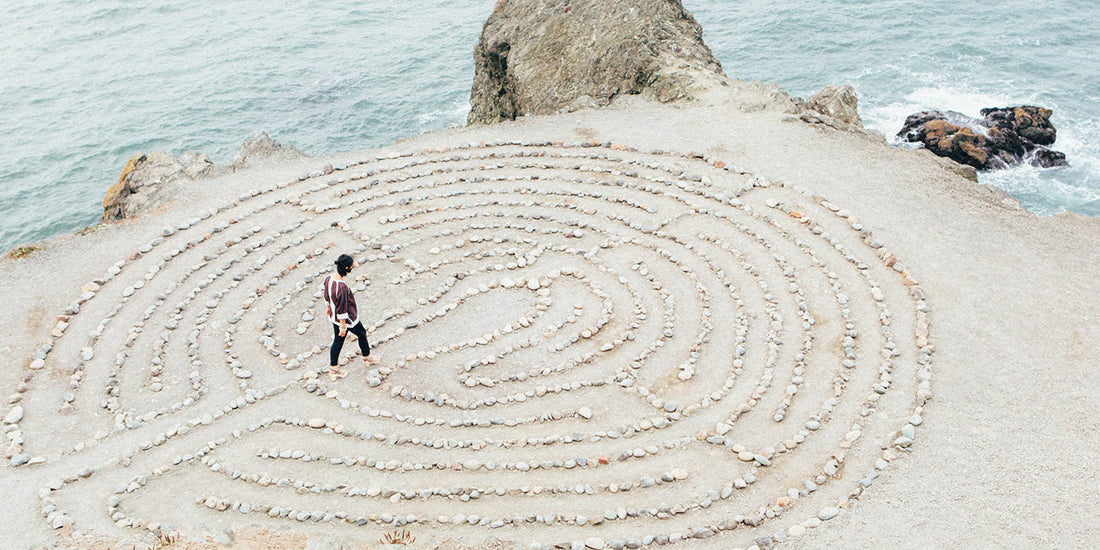 a woman walking through a pebble maze