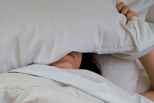 a woman sleeping with a pillow on her head