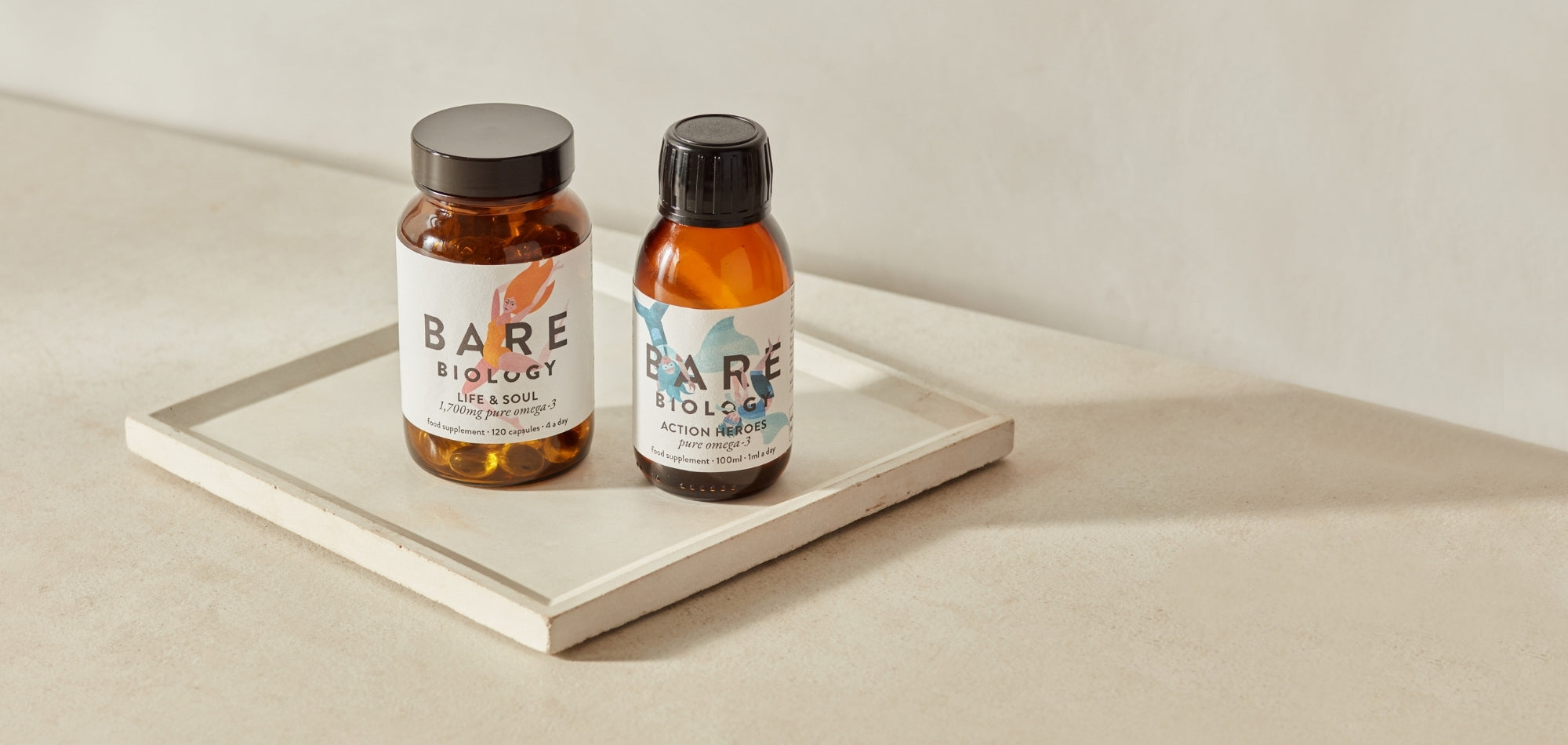 Two bottles of Bare Biology Omega-3 fish oil products on a white surface with a neutral background