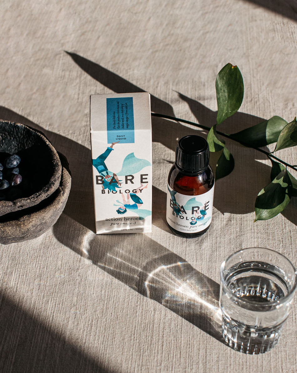 action heroes omega 3 liquid for kids in the sun with water and a bowl of blueberries