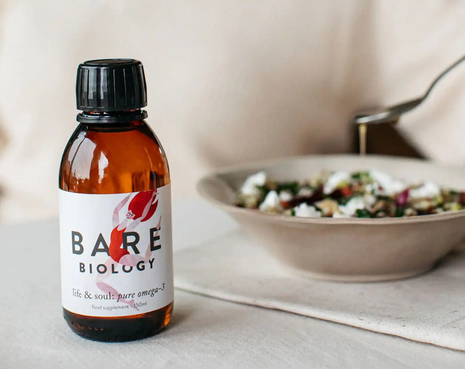bare biology high strength omega 3 liquid drizzled onto salad