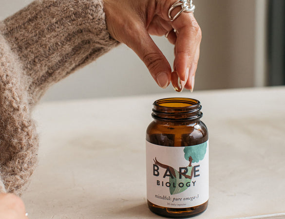 bare-biology-mindful-omega-3-fish-oil-capsules-in-jar-held-by-model