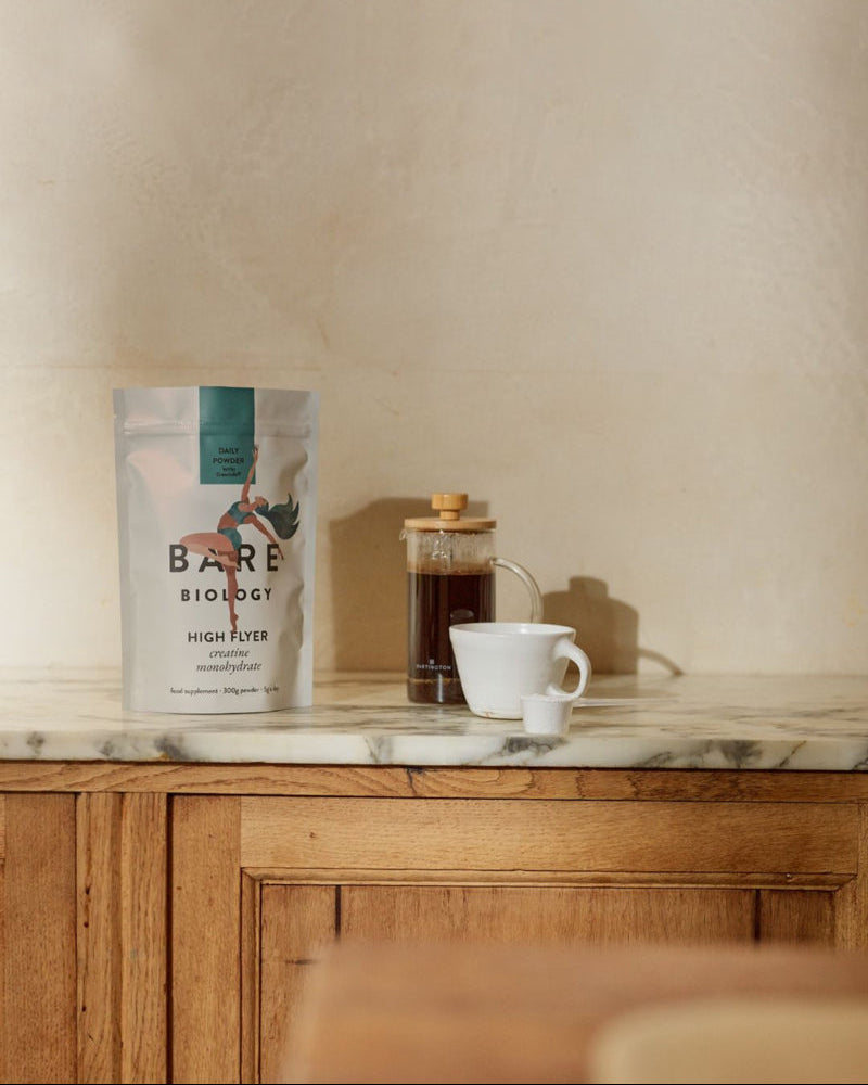 Bare Biology High Flyer Creatine Pouch next to a cafetière on a marble countertop with a white mug.