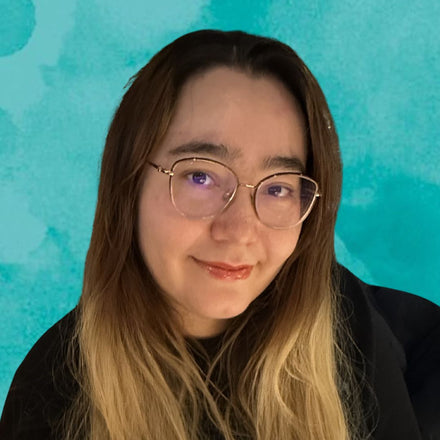 Amazon manager with glasses and long hair against a teal background