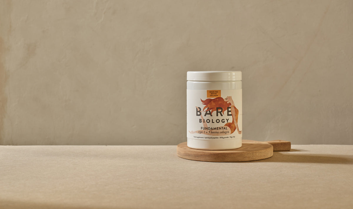 Bare Biology bovine collagen product on a wooden stand with a beige background