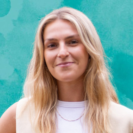 Woman with blonde hair against a teal background
