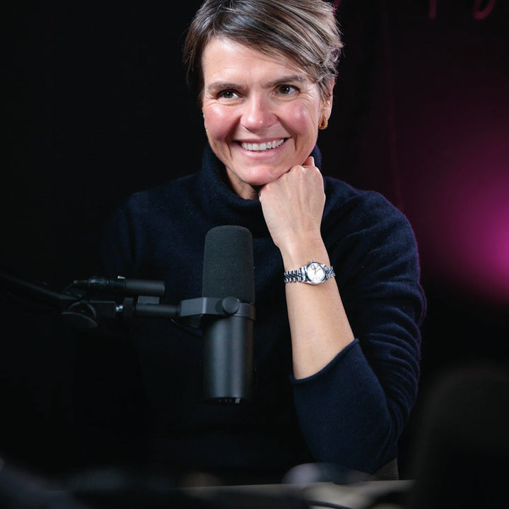 melanie lawson behind a podcast microphone hosting her show