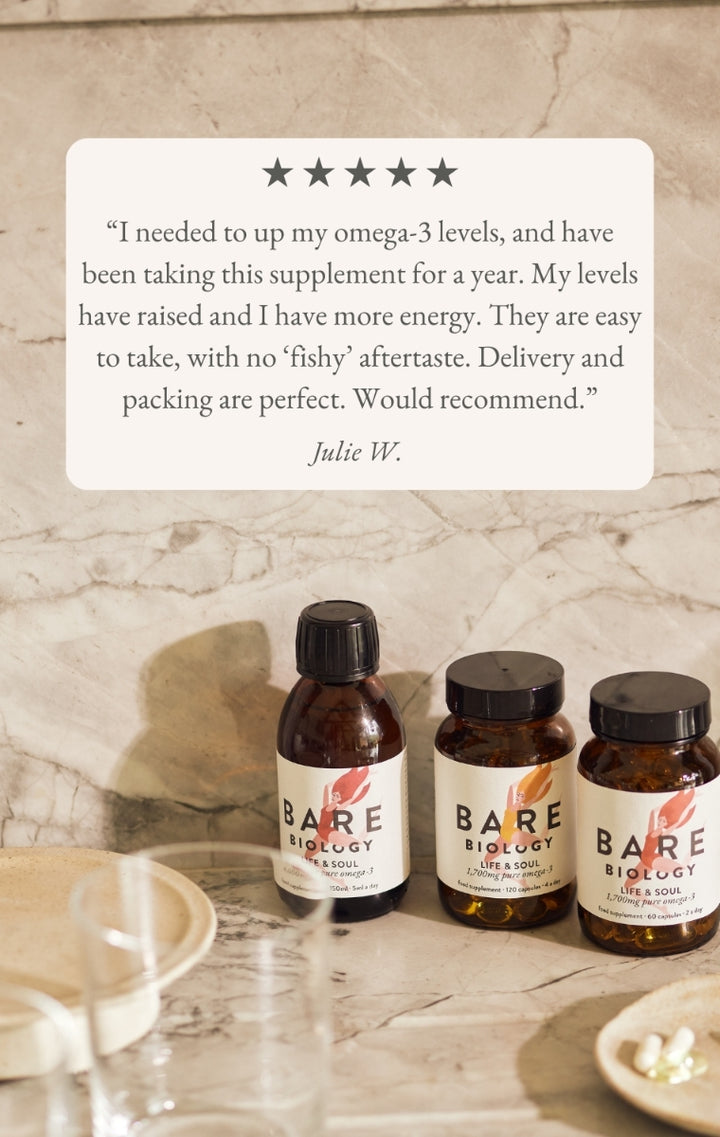 Bare Biology supplement bottles on a marble surface with a five star customer review above.