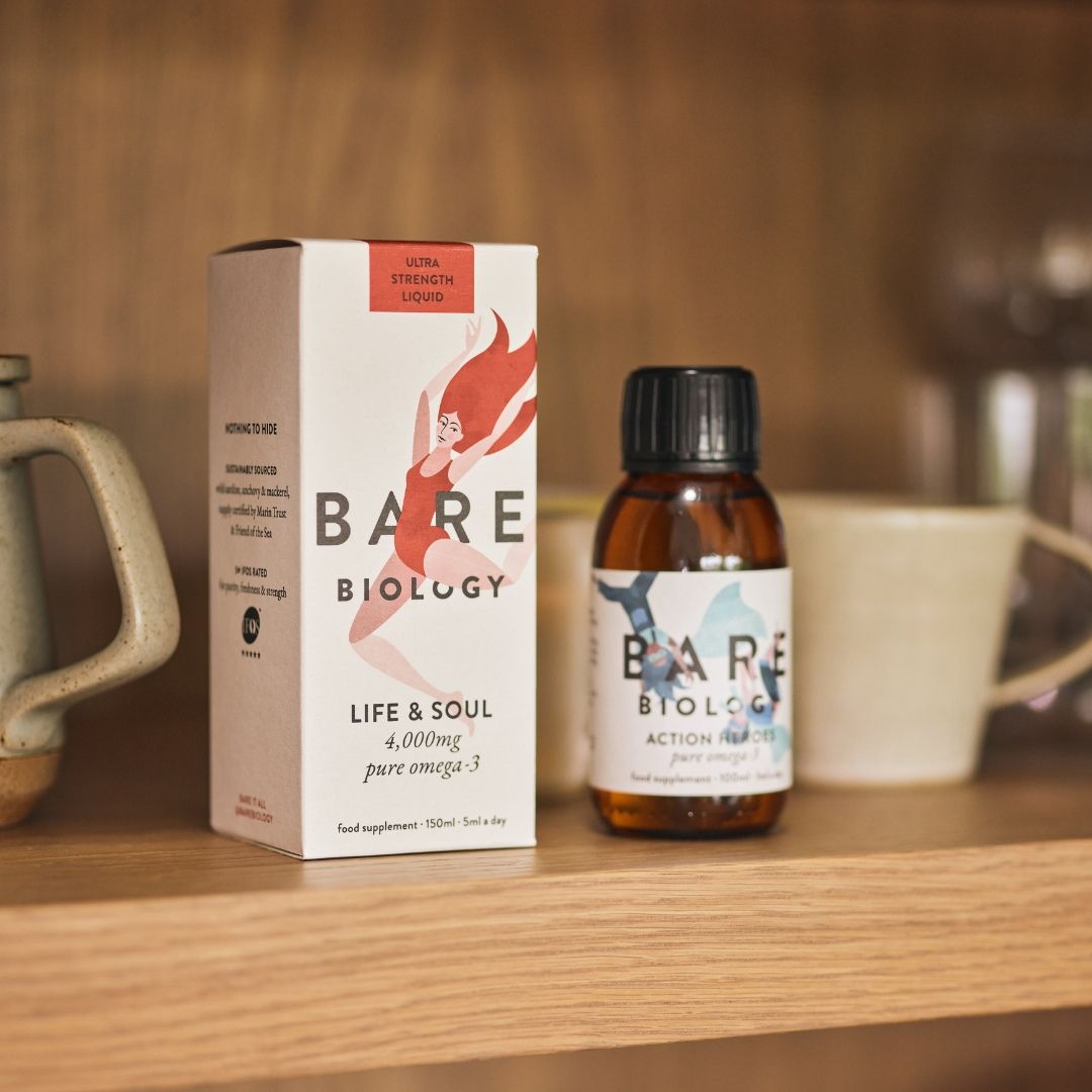 Bare Biology supplement bottle and box on a wooden surface with a blurred background