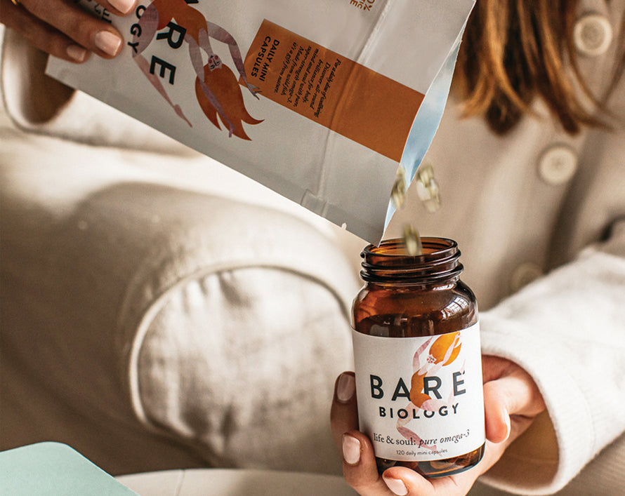 woman filling jar with pouch of bare biology life and soul mini capsules