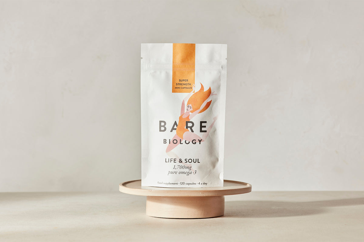 Bare Biology supplement pouch on a wooden stand with a plain background
