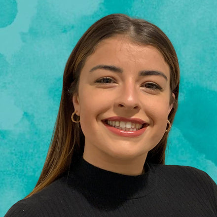 Woman smiling against a teal background