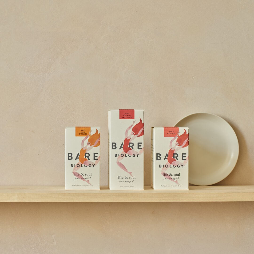 3 Bare Biology omega-3 products displayed next to each other on a wooden shelf and neutral coloured wall backing