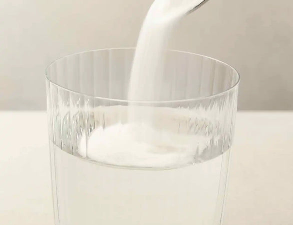 bare biology skinful marine collagen powder being poured into a glass of water