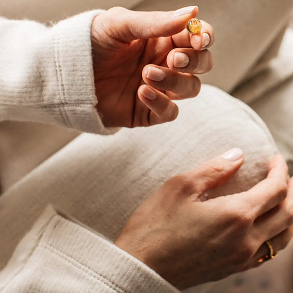 a woman holding a bare biology mini omega 3 capsule