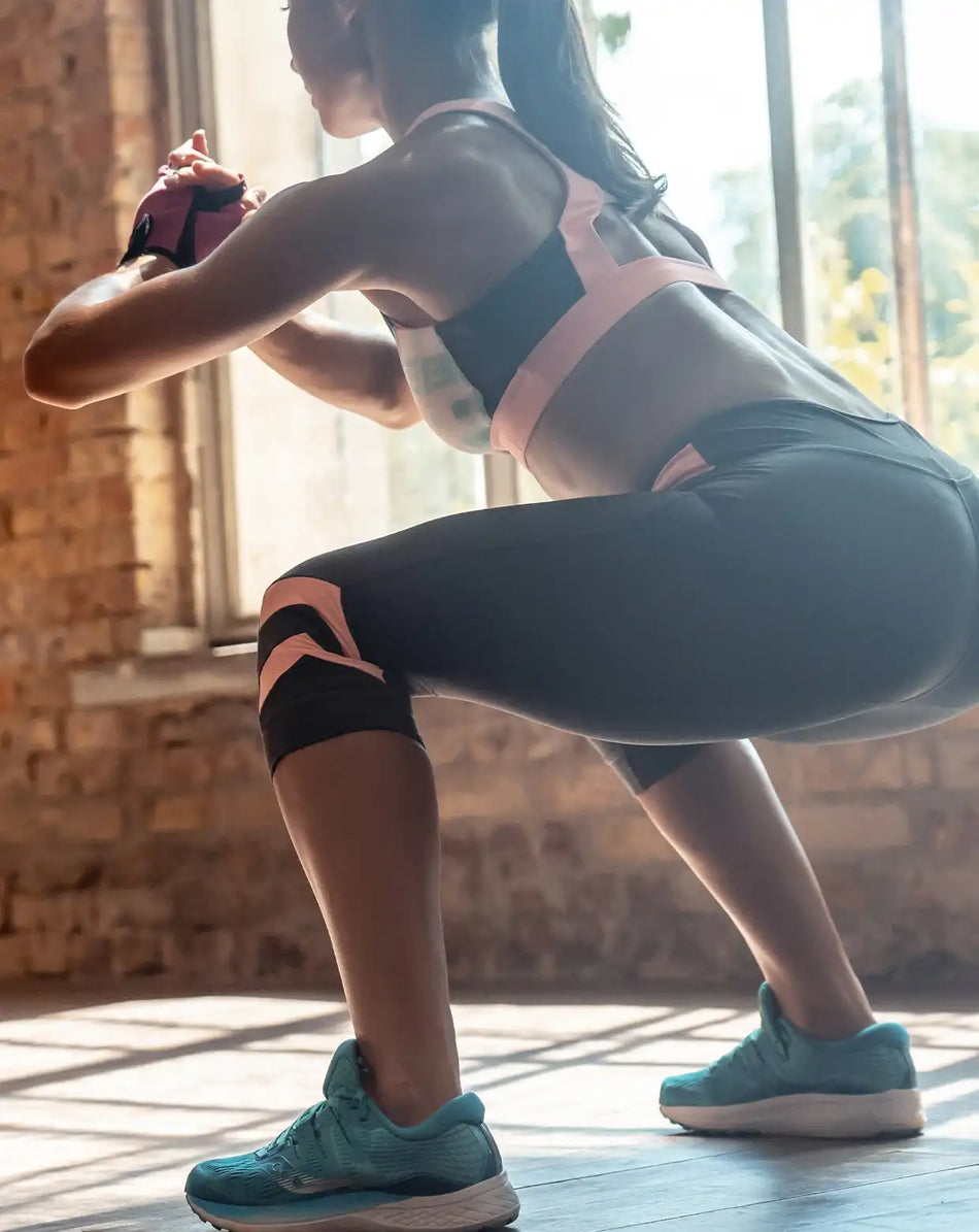 a woman doing squats in a gym