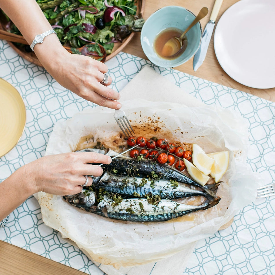 fish and salad with tomatoes on a dining table