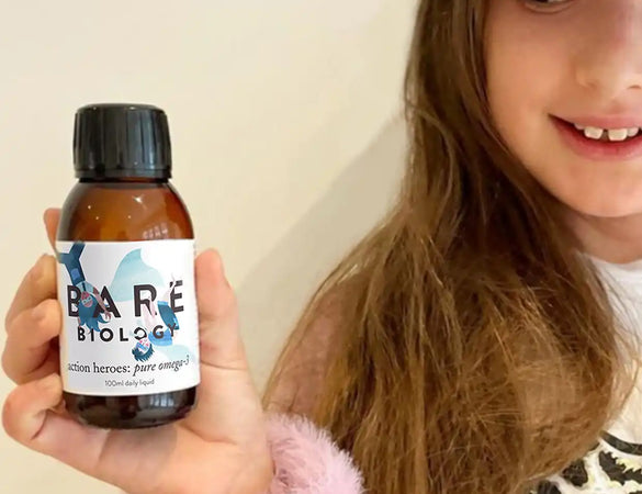 a child holding bare biology action heroes omega 3 liquid for brain health