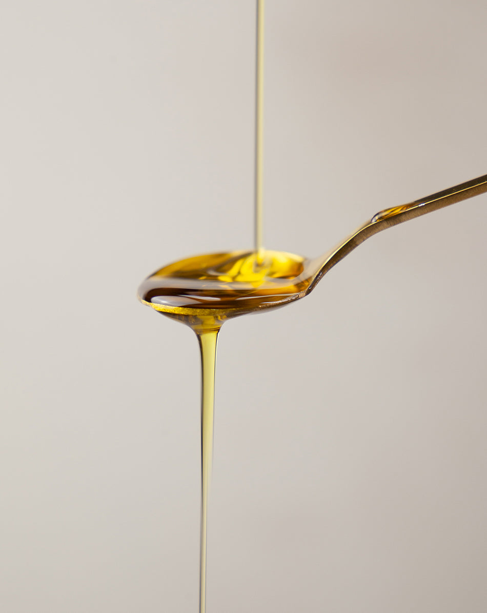 omega 3 fish oil liquid pouring on a gold spoon