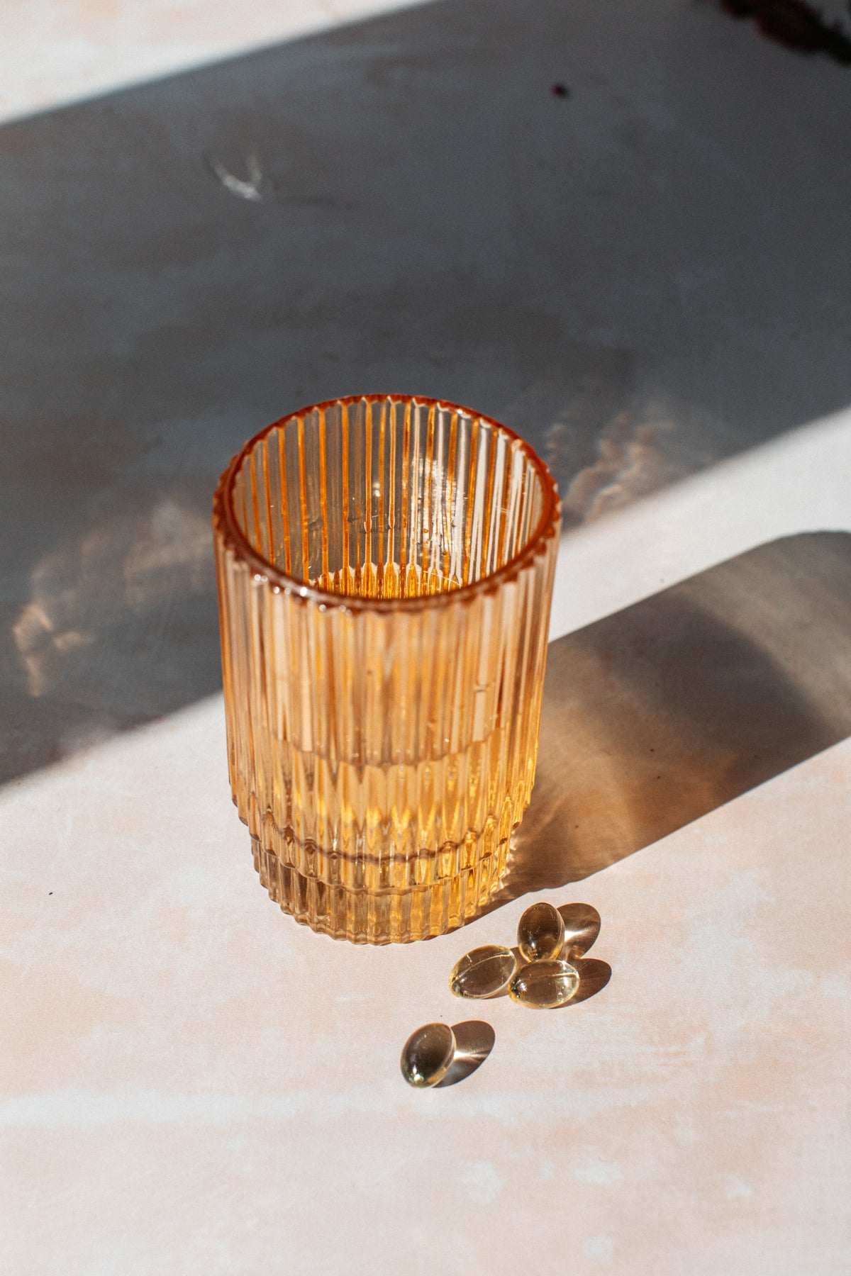 life & soul mini capsules with a glass of water in sunlight