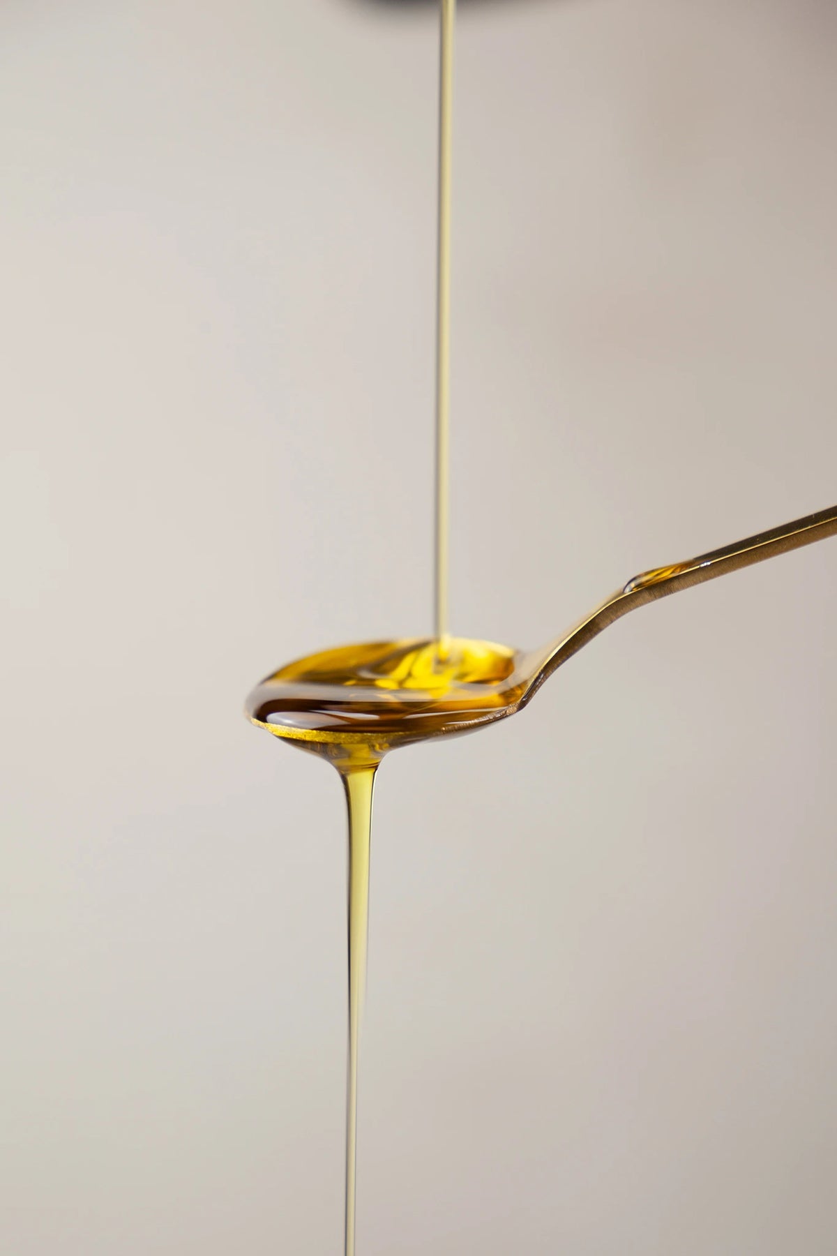 bare biology high strength life & soul omega 3 fish oil liquid pouring on a gold spoon 