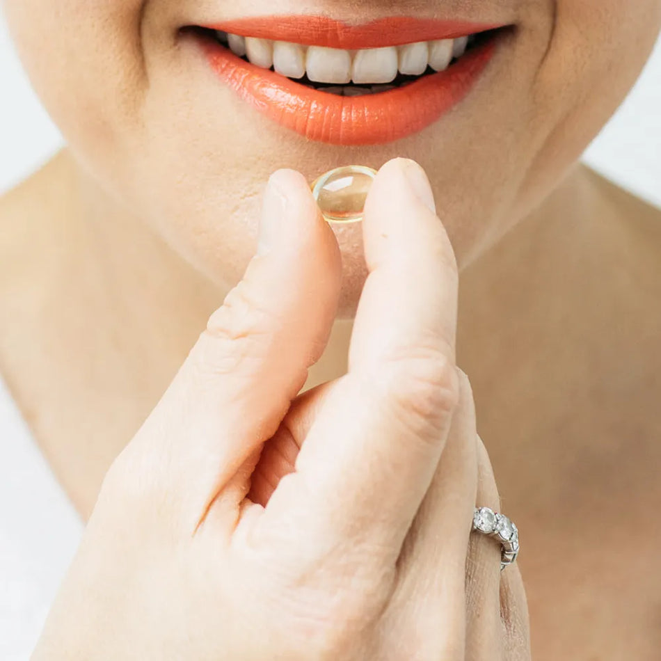 bare biology life and soul mini omega 3 capsule next to models mouth