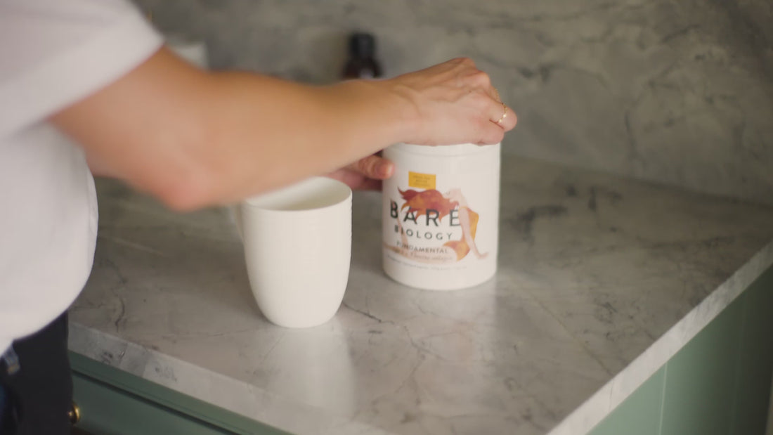 Video of woman scooping out Fundamental Bovine Collagen out of product tub on a marble kitchen counter into a mug