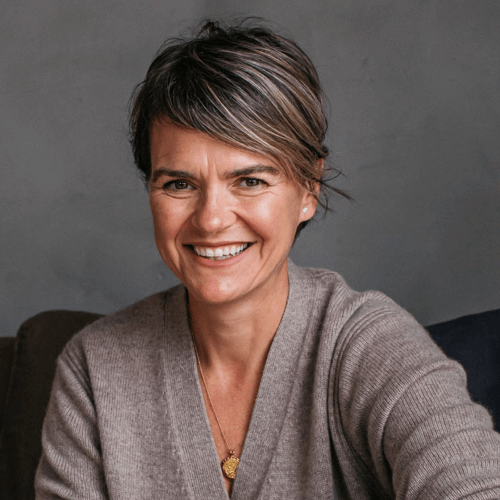 Founder of bare biology Melanie Lawson smiling in grey cardigan and gold necklace