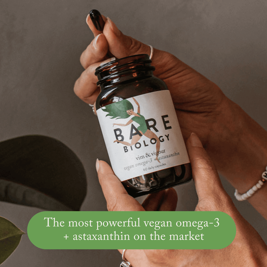 a woman holding bare biology vim & vigour vegan omega 3 supplement jar and capsule